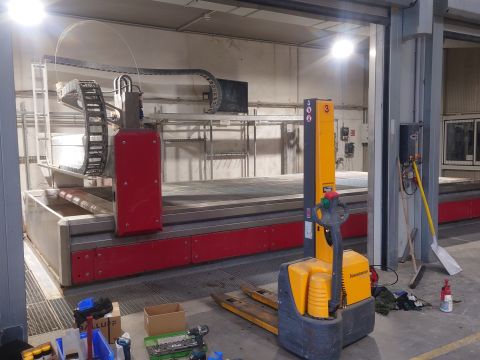 ein Waterjet bei der Firma Peneder mit Werkzeug und einem elektrischen Hubwagen davor